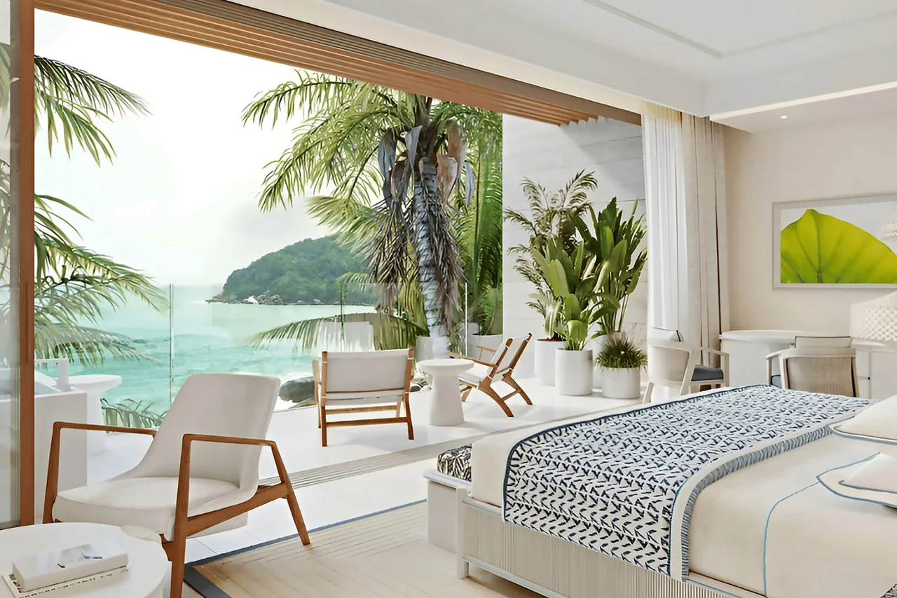 A private terrace with lounge chairs and palms framing the sea at The Setai, St. Maarten